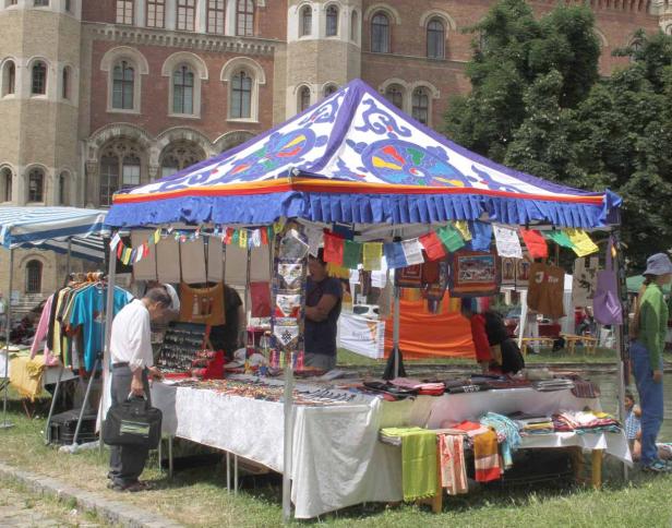 Ein Marktstand mit tibetischen Artikeln vor einem Backsteingebäude.