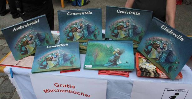 Auf einem Tisch liegen Märchenbücher von Aschenputtel in verschiedenen Sprachen zum Verkauf.