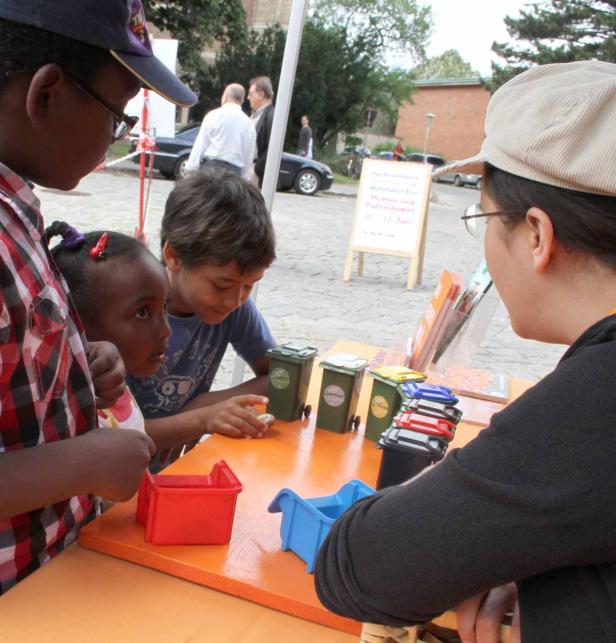 Kinder lernen spielerisch etwas über Mülltrennung.