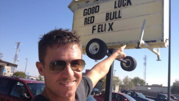 Baumgartner Ein Mann zeigt auf ein Schild mit der Aufschrift „Good Luck Red Bull Felix“.