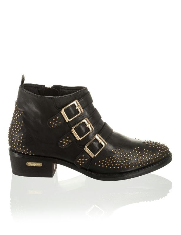 Ein schwarzer Lederstiefel mit goldenen Schnallen und Nieten.