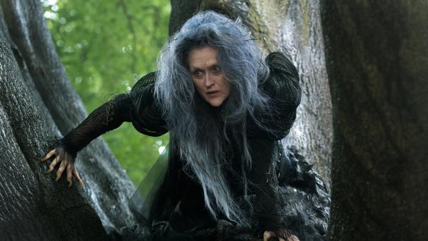Meryl Streep als Hexe im Film „Into the Woods“ klettert auf einen Baum.