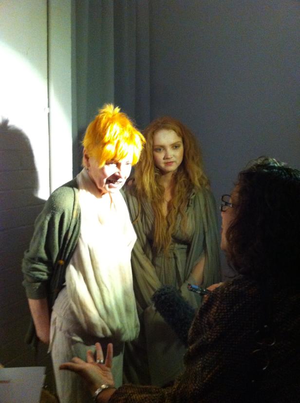 Zwei Frauen in Kostümen werden von einer Person interviewt.