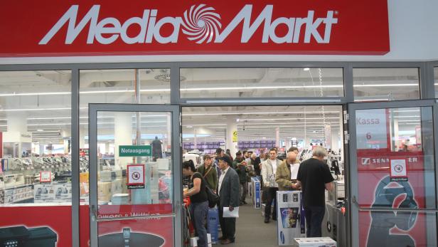 Kunden betreten einen Media Markt durch die offenen Eingangstüren.