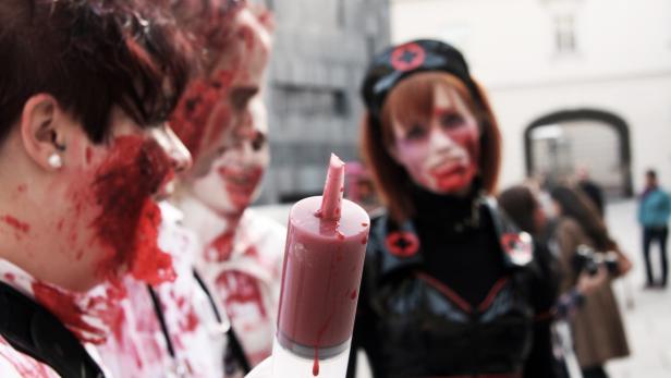 Eine Gruppe als blutige Zombies verkleideter Menschen bei einer Veranstaltung.