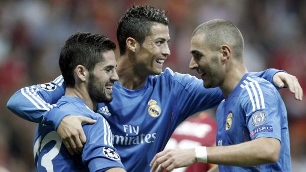 Cristiano Ronaldo, Karim Benzema und Isco feiern gemeinsam in ihren Trikots von Real Madrid.