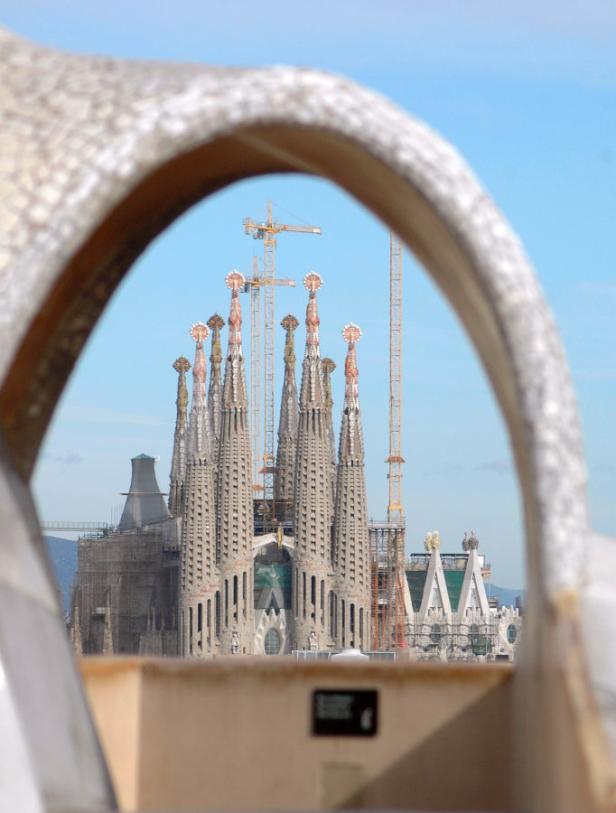Die Sagrada Familia in Barcelona, gesehen durch einen steinernen Bogen hindurch.