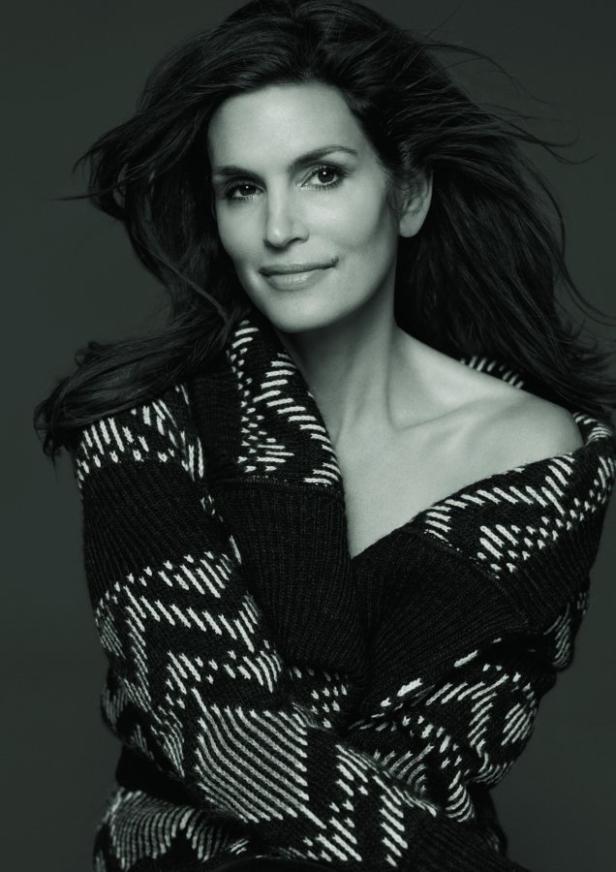 Ein Schwarzweißporträt von Cindy Crawford mit einem gemusterten Cardigan.