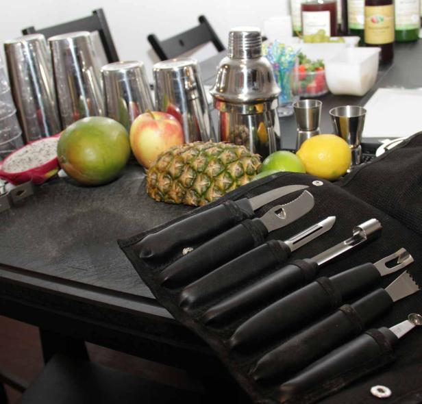 Eine Auswahl an Barwerkzeugen und frischen Früchten auf einem Tisch.