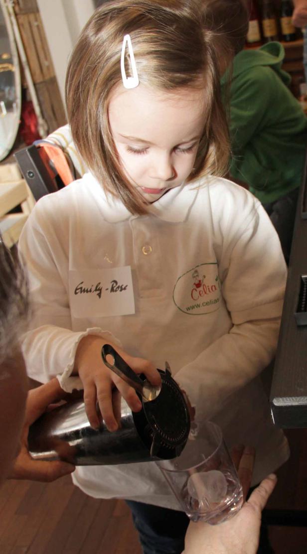 Ein junges Mädchen namens Emily-Rose gießt ein Getränk in ein Glas mit Eiswürfeln.