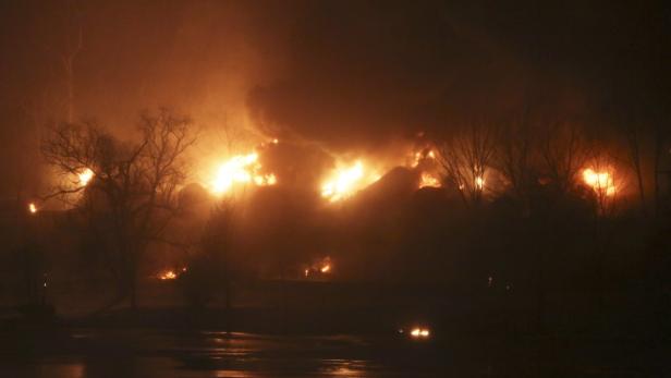 In der Nacht wüten Flammen und Rauch in einer Baumlandschaft.