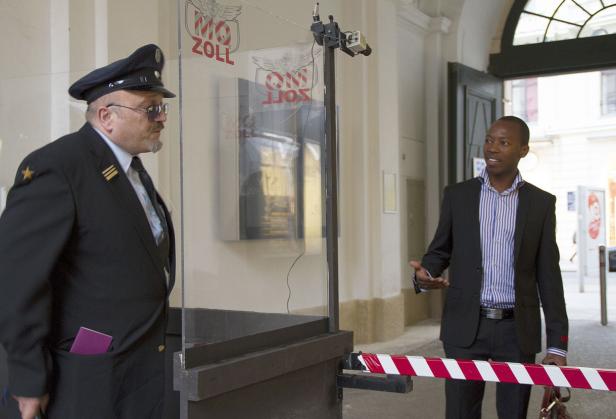 Ein Zollbeamter kontrolliert einen Mann an einem Grenzübergang.