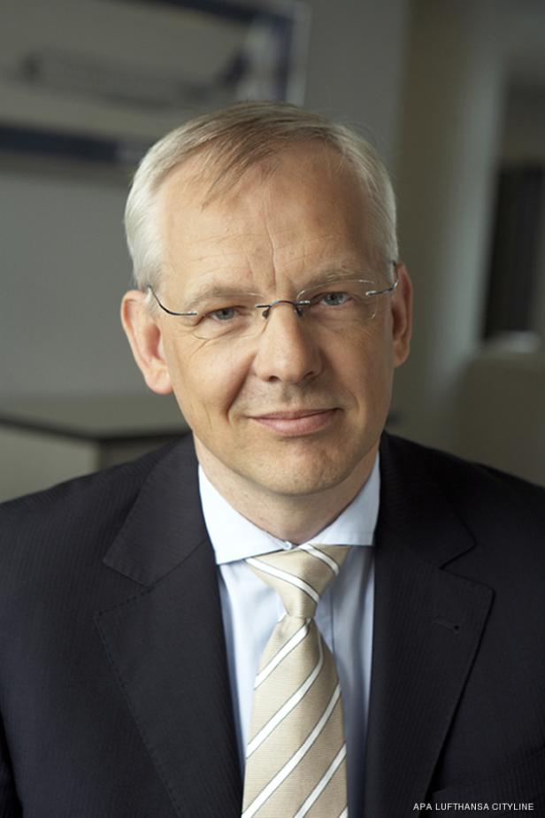 Ein Mann mit Brille, Anzug und Krawatte blickt in die Kamera.