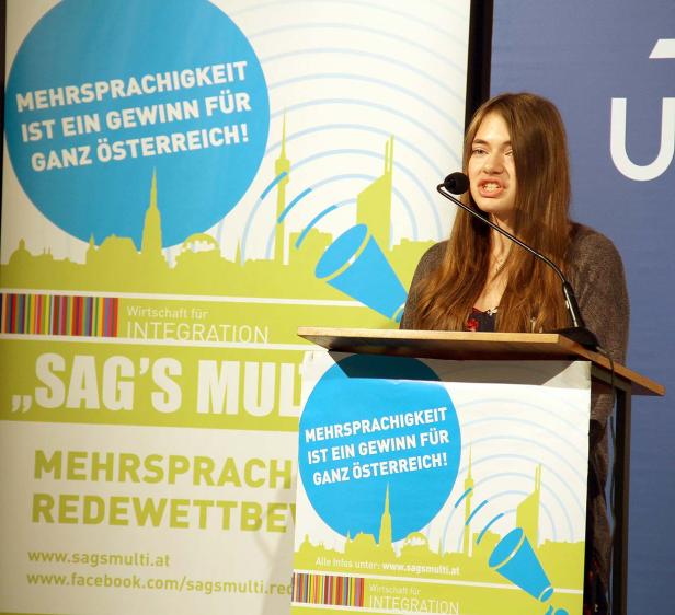 Eine junge Frau spricht bei einem Redewettbewerb zum Thema Mehrsprachigkeit.