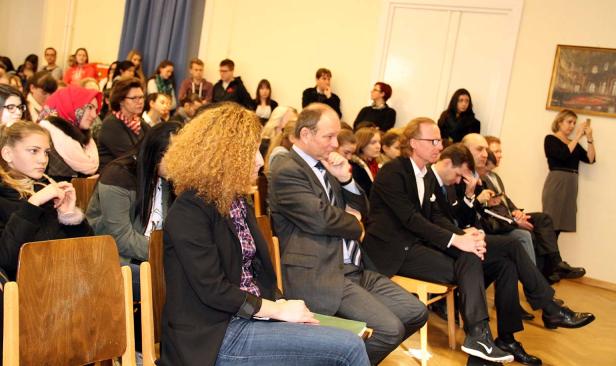 Zuschauer sitzen bei einer Veranstaltung in einem Raum.