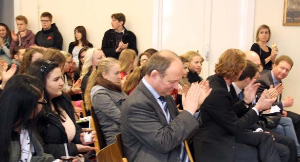 Ein Publikum applaudiert bei einer Veranstaltung.