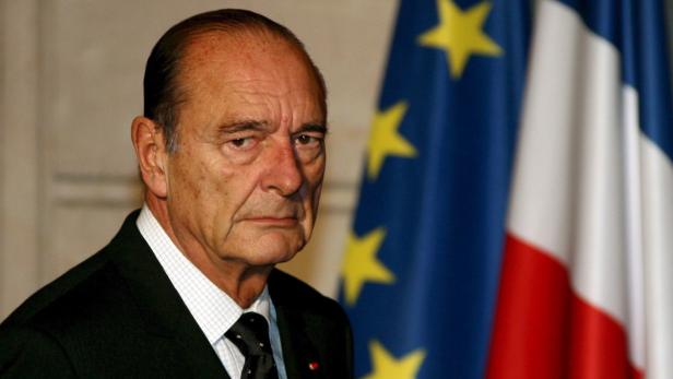 Ein Porträt von Jacques Chirac vor einer französischen Flagge.