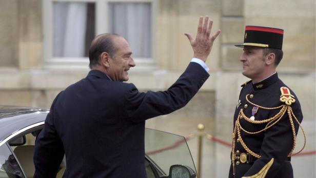 Jacques Chirac winkt einem Soldaten in Uniform zu.
