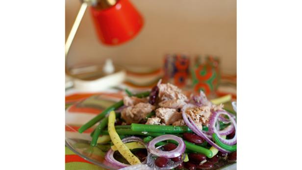 Ein Teller mit einem Salat aus grünen Bohnen, roten Zwiebeln, Thunfisch und roten Bohnen.