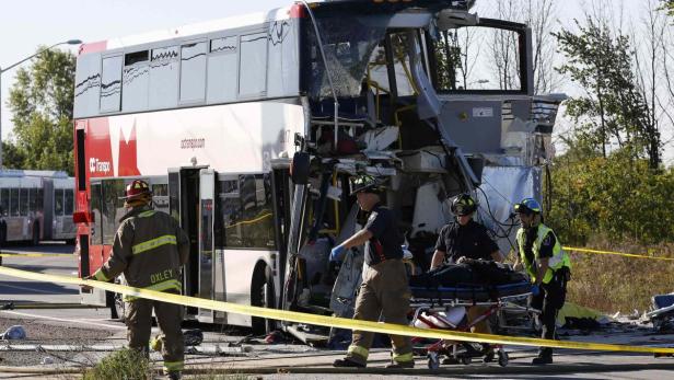 Rettungskräfte bergen einen Verletzten aus einem verunglückten Doppeldeckerbus.