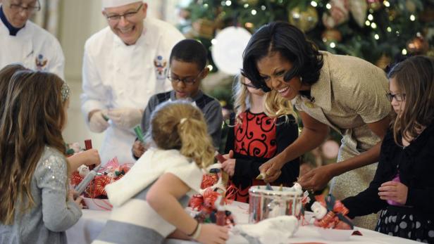 Michelle Obama hilft Kindern beim Dekorieren von Weihnachtsschmuck.