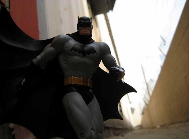 Eine Batman-Figur steht in einem dunklen Gang.