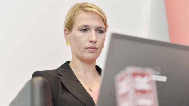 Live Chat mit Kathrin Nachbaur Eine blonde Frau mit Blazer und goldener Halskette arbeitet am Computer.
