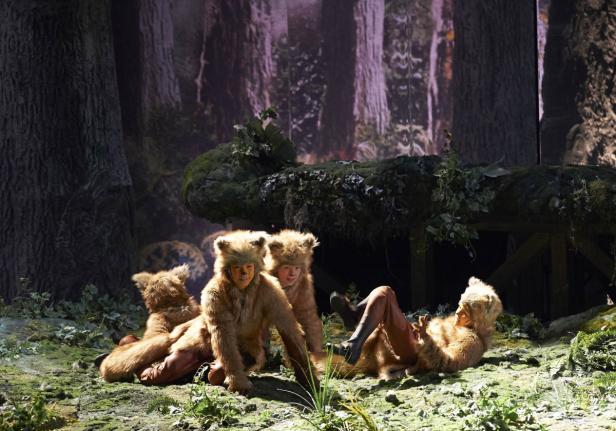 Eine Gruppe von Schauspielern in Bärenkostümen posiert auf einer Waldbühne.