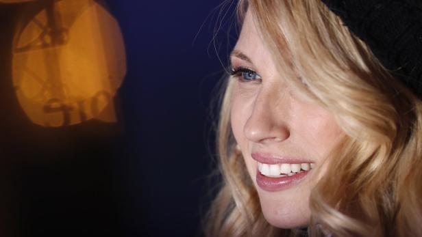 Nahaufnahme einer lächelnden Frau mit blonden Haaren und blauem Auge.