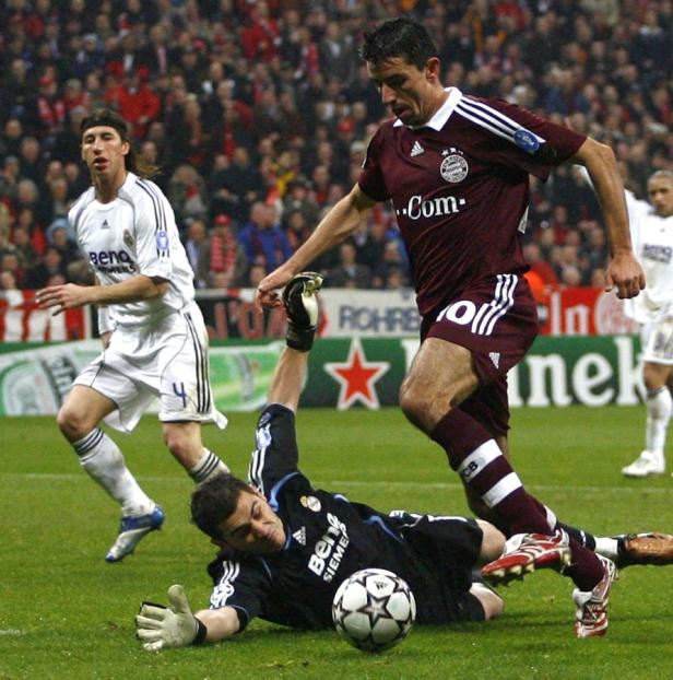 Ein Fußballspieler des FC Bayern München dribbelt an Iker Casillas von Real Madrid vorbei.