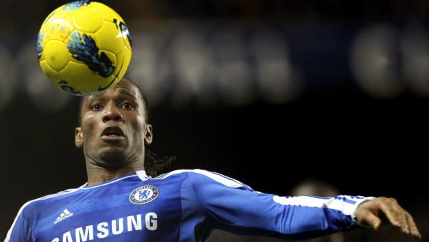 Didier Drogba köpft einen gelben Fußball.