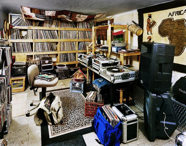 Ein Raum voller Schallplatten, DJ-Equipment und einer Afrikakarte an der Wand.