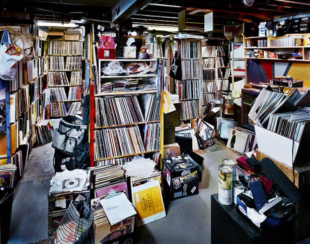 Ein Raum ist vollgestellt mit Regalen und Kisten voller Schallplatten.