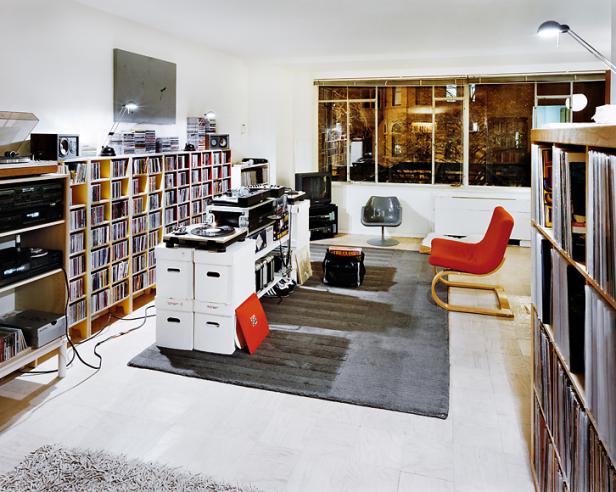 Ein Wohnzimmer mit Regalen voller CDs und Schallplatten, Plattenspielern und zwei Sesseln.