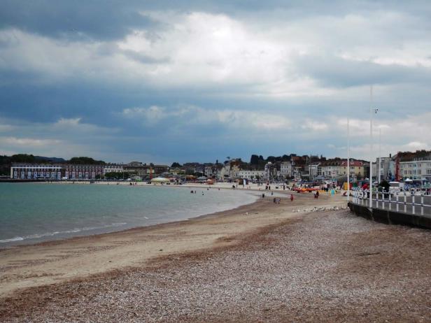 Ein Küstenort mit einem Strand unter einem bewölkten Himmel.