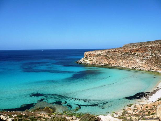 Eine malerische Bucht mit türkisfarbenem Wasser und einer felsigen Küste.