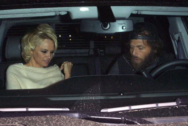 Pamela Anderson sitzt mit einem bärtigen Mann in einem Auto.
