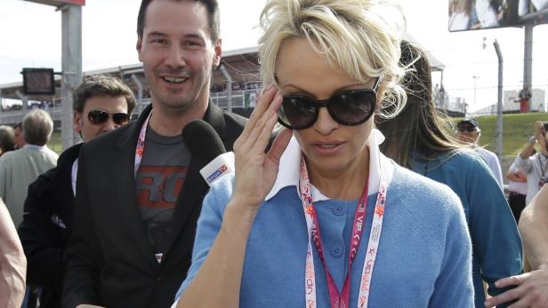Pamela Anderson und Keanu Reeves bei einer Sportveranstaltung.