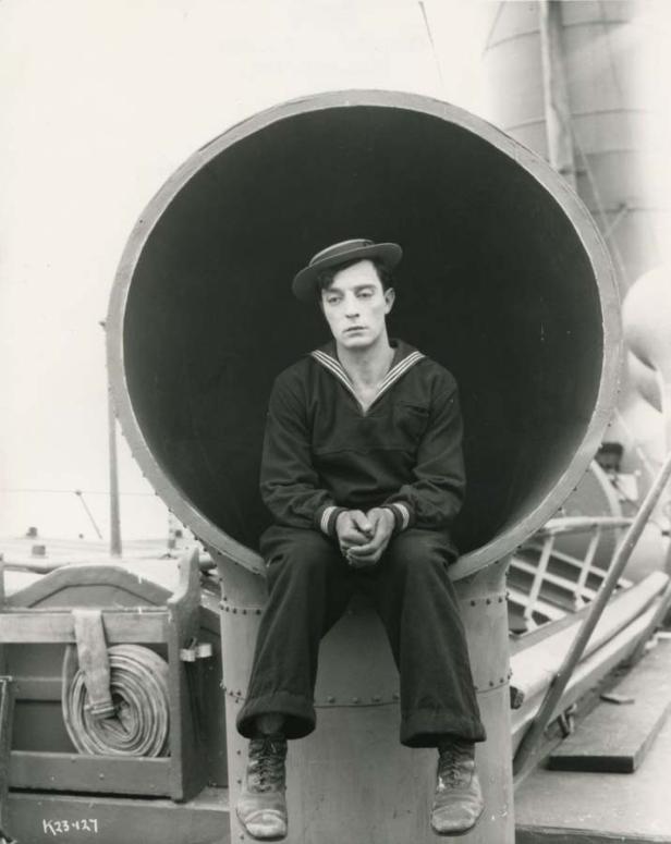 Buster Keaton als Seemann sitzt in einem großen Rohr.