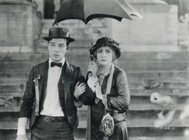 Ein Mann und eine Frau stehen im Regen unter einem Regenschirm.