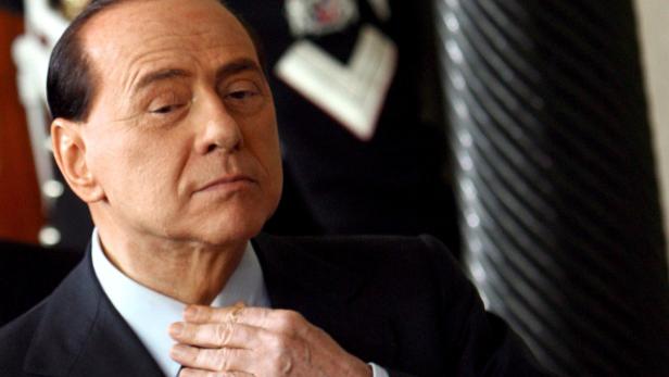 Silvio Berlusconi richtet sein Hemd.