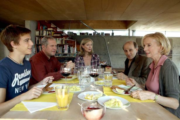 Eine Familie sitzt an einem Tisch und isst gemeinsam zu Mittag.