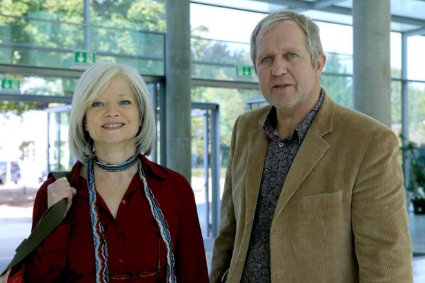 Ein Mann und eine Frau stehen in einem hellen Gebäude.