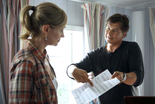 Ein Mann erklärt einer Frau Notenblätter.