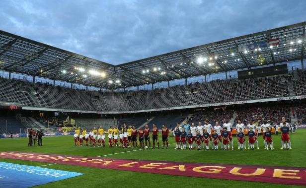 Fußballspieler stehen vor einem Europa League Banner auf dem Rasen.