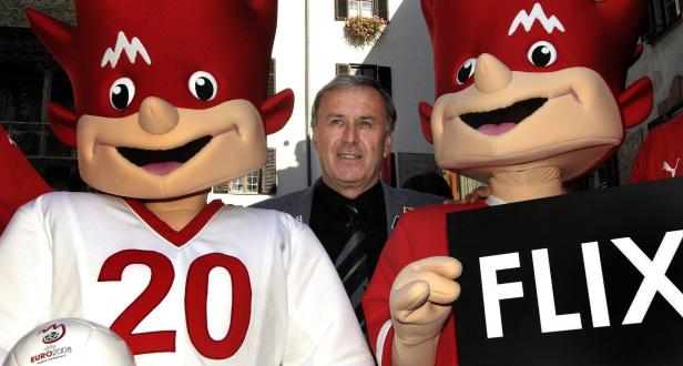 Ein Mann steht zwischen zwei Maskottchen der UEFA Euro 2008, die „Flix“ darstellen.