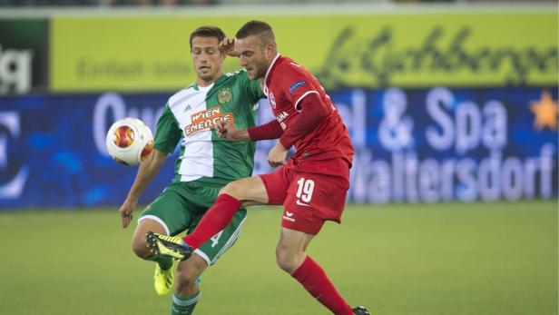 Zwei Fußballspieler kämpfen um den Ball während eines Spiels.