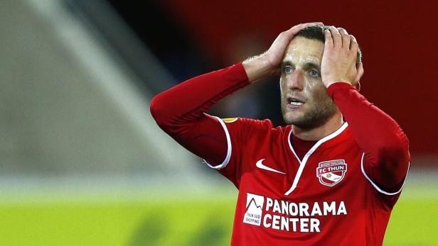 Ein enttäuschter Fußballspieler des FC Thun hält sich die Hände an den Kopf.