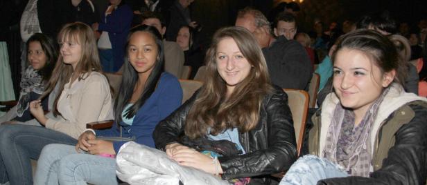 Eine Gruppe junger Frauen sitzt in einem Theater oder Kino.