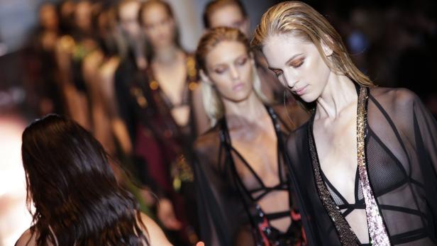 Models präsentieren transparente Kleidung auf dem Laufsteg.